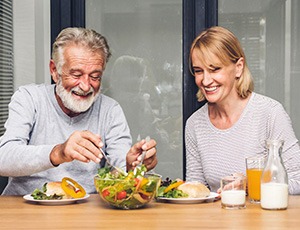 A senior couple happily eating a healthy breakfast together