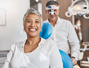 A mature woman smiling while sitting in a dentist’s chair