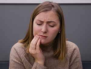 Woman with toothache at emergency dentist