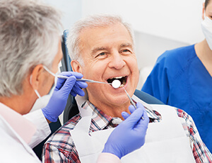 Older male patient receives gum disease screening