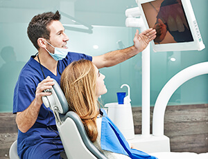 Dentist and patient view images of teeth on monitor